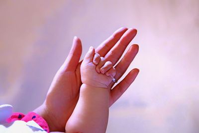 Cropped hands of mother with newborn baby girl