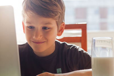 Smiling boy using laptop