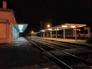 Illuminated railroad station platform at night