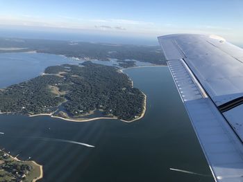 Aerial view of sea and airplane flying in sky