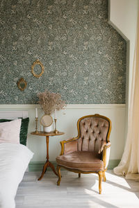 Classic bedroom interior. a brown armchair by the window and the bed and the bedside table