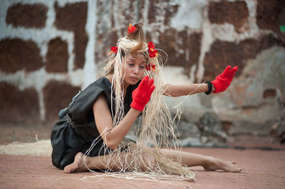 Full length of woman wearing hat against wall