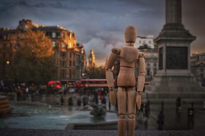 Statue in city against sky