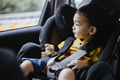 Baby boy sitting in car seat