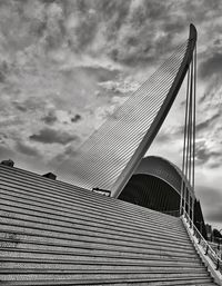 Low angle view of suspension bridge against cloudy sky