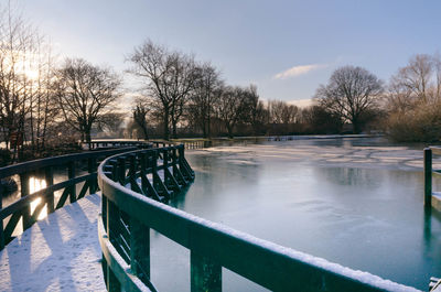 Scenic view of swimming pool by lake against sky during winter