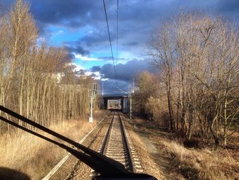 Railroad tracks against cloudy sky