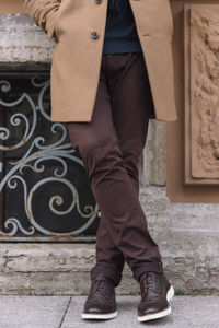 Photo of unrecognizable male in fashionable wool autumn beige coat, brown pants and leather shoes