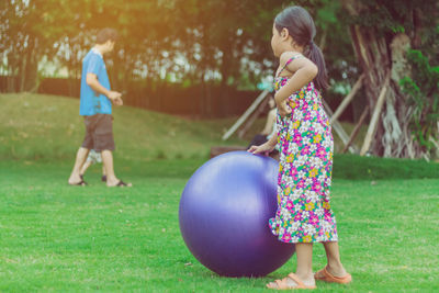 Side view of girl playing with grass