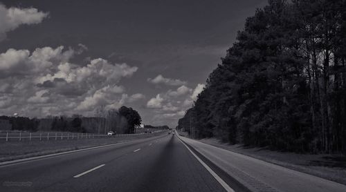 Road amidst trees against sky