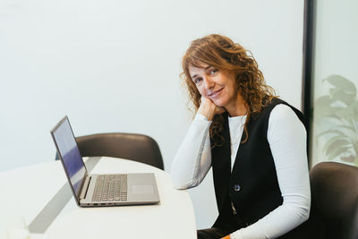 Young woman using laptop while sitting at office