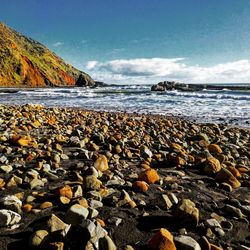 Pebbles on beach against sky