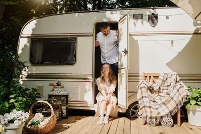 Camping and travelling. happy couple relaxing outdoors near trailer man and woman on their road trip