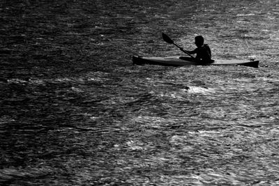 View of man kayaking in sea