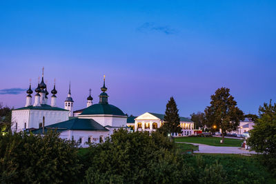 Panoramic view of buildings and trees against blue sky