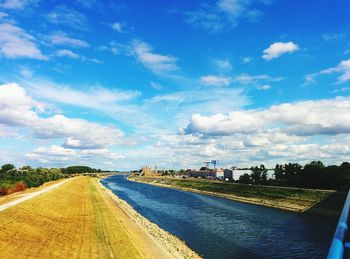 Road by city against blue sky