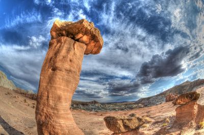 Scenic view of rock formations against cloudy sky