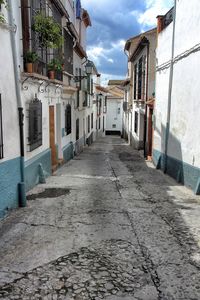 Alley amidst buildings against sky