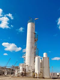 Low angle view of factory against blue sky
