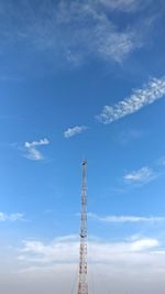 Low angle view of communications tower against blue sky