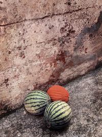 High angle view of balls on rock against wall