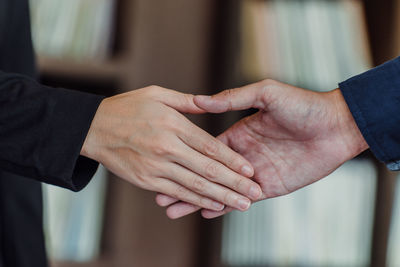 Cropped image of colleagues shaking hands in office