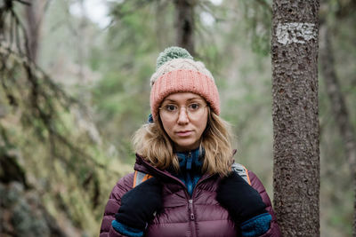 Portrait of a woman solo hiking through a forest in sweden in winter