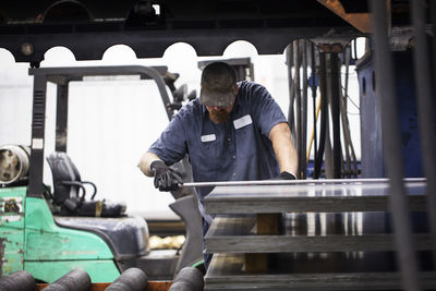 Worker working on metal sheet in steel industry factory