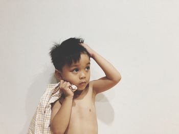 Shirtless boy standing against white background