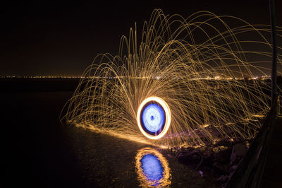 Illuminated ferris wheel against sky at night