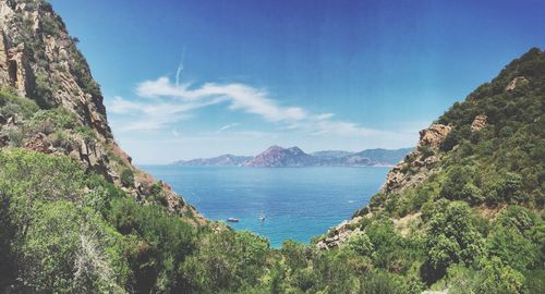 Idyllic shot of sea and mountains against sky