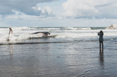 Full length of man standing on beach against sky