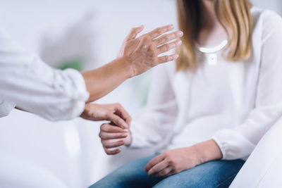 Cropped hands of doctor giving therapy to patient at hospital