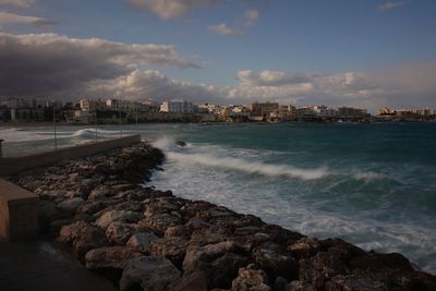 Scenic view of sea by city against sky