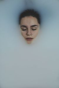 Close-up of young woman against white background