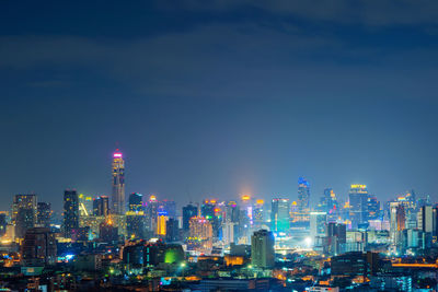 Illuminated buildings against sky at night