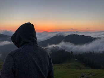 Rear view of man looking at mountain against sky