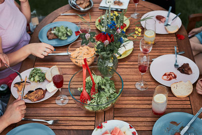 Family having a meal from grill during summer picnic outdoor dinner in a home garden