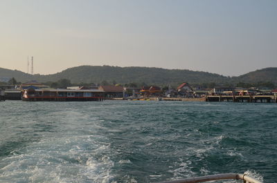 Scenic view of sea by buildings against clear sky