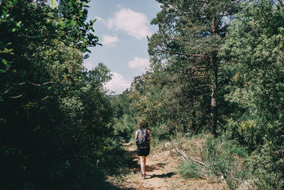 Girl walking along a small path in the mountain of prades, tarragona, spain. on a sunny summer day