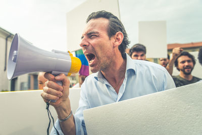 Man shouting on megaphone during protest in city