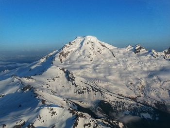 Scenic view of snowcapped mountains against clear blue sky