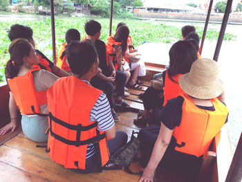 Rear view of people enjoying in water