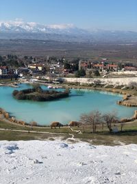 High angle view of buildings by lake against sky