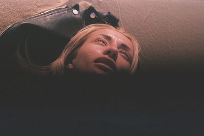 Close-up portrait of young woman lying down