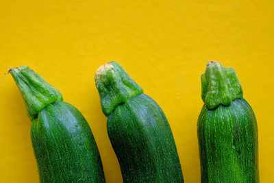 Close-up of green chili pepper against yellow background