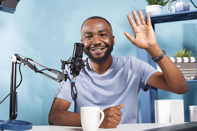 Portrait of young man using mobile phone in cafe