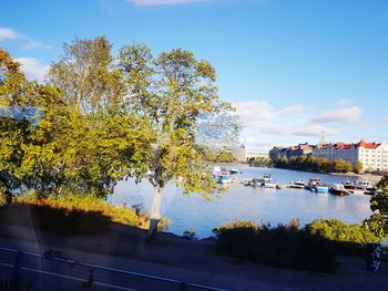 Scenic view of river by buildings against sky