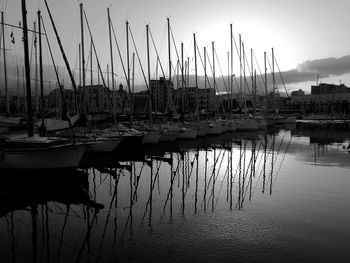 Boats moored at harbor against sky