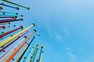 Low angle view of chain swing ride against blue sky